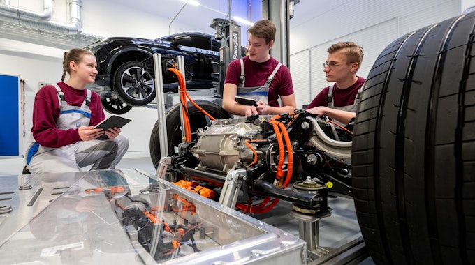 Die angehenden KfZ-Mechatroniker Simona Barthel, Maurice Kipping (M) und Louis Rose befassen sich mit dem Modell eines Modularen E-Antriebs-Baukasten von VW.&nbsp;