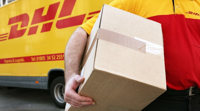 Symbolbild: Ein Mitarbeiter des Paketdienstleisters DHL der Deutschen Post trägt am 12.11.2008 in Köln ein Paket zum Kunden.