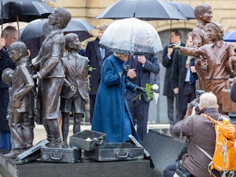 Königsgemahlin Camilla legt beobachtet von König Charles III. von Großbritannien, am Bahnhof Dammtor am Denkmal „Kindertransport, der letzte Abschied“ eine weiße Rose nieder.