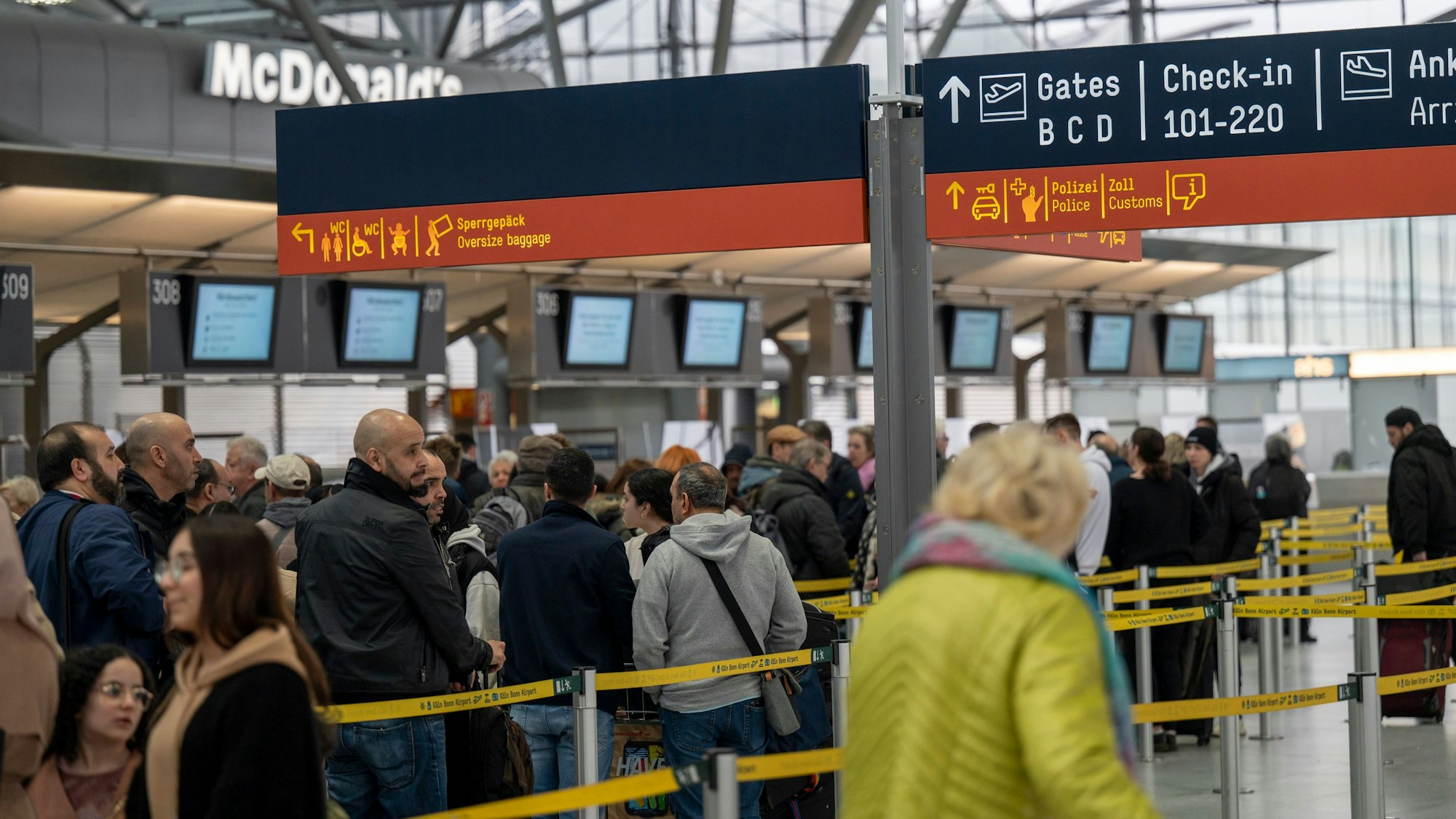 Am Flughafen checken viele Reisende zu ihrem Flug in den Urlaub ein.