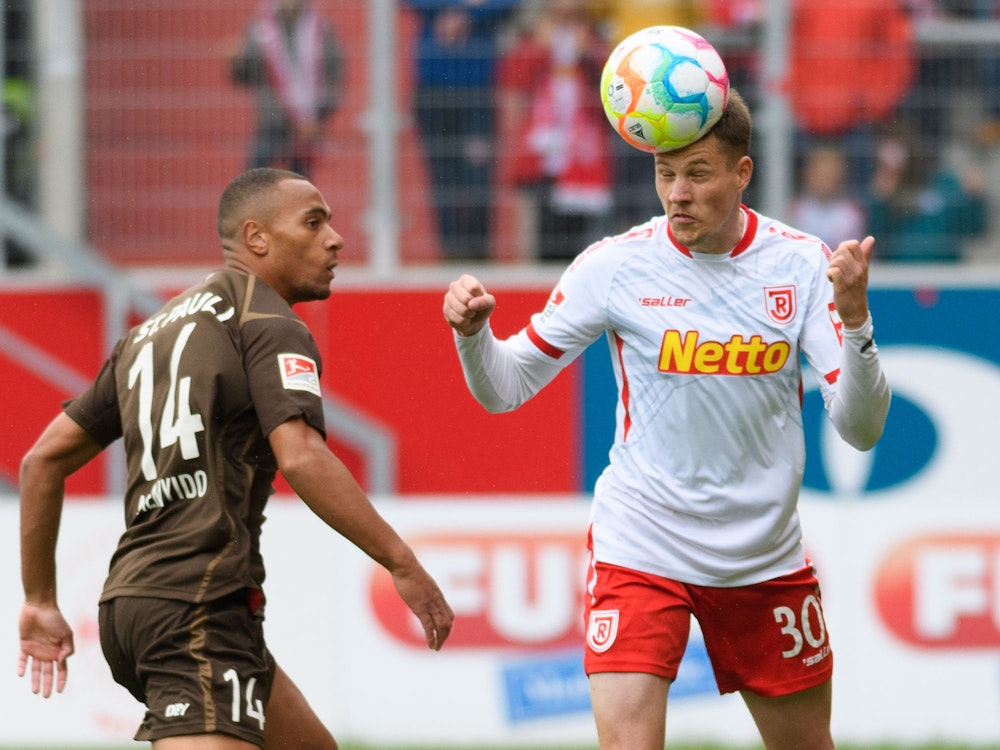 Regensburgs Christian Viet und Etienne Amenyido vom FC St. Pauli kämpfen um den Ball.