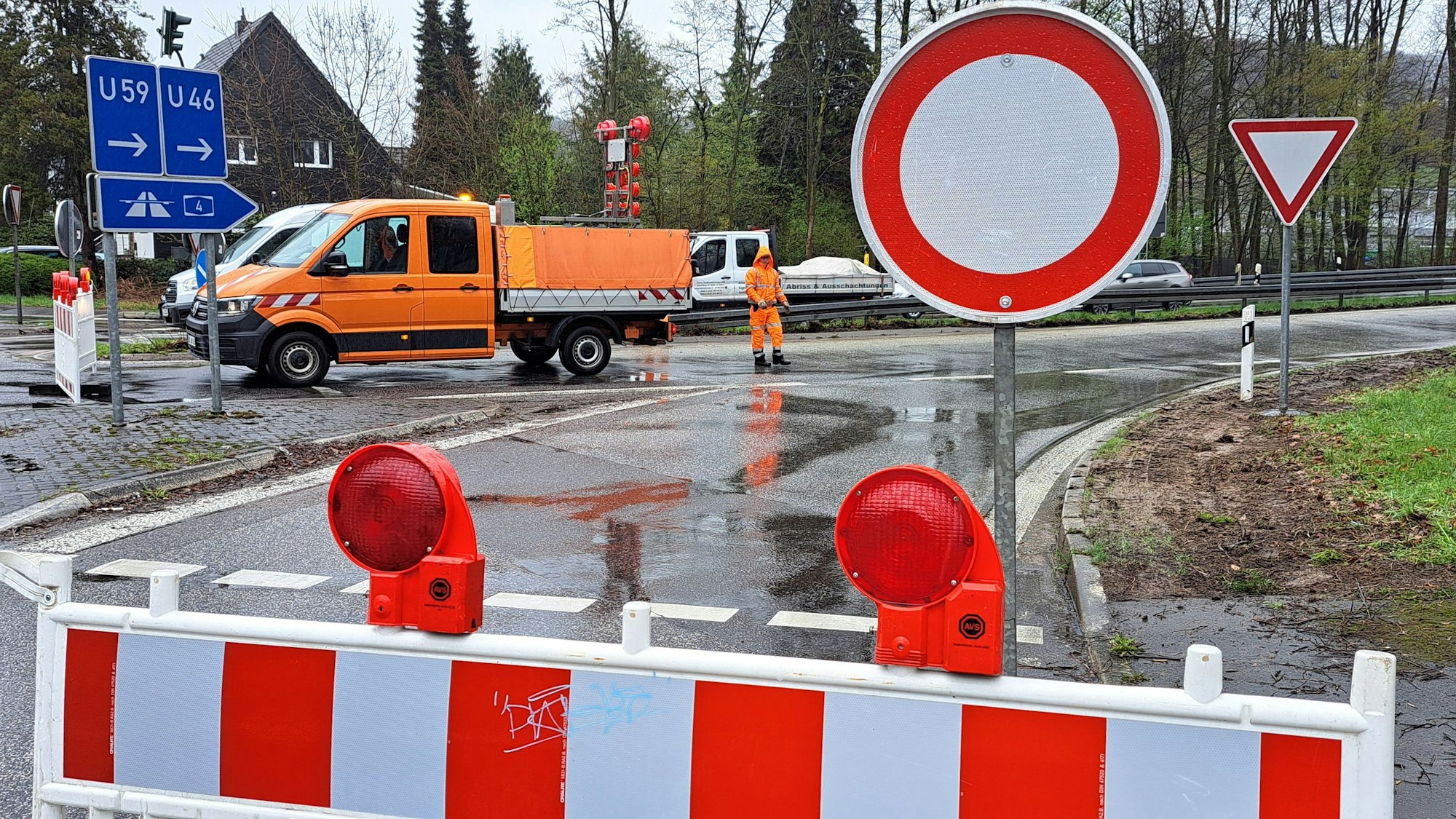 Eine rot-weiße Warnbake samt Durchfahrt-verboten-Schild versperrt die Zufahrt zur A4. Im Hintergrund ist ein Baufahrzeug zu sehen.