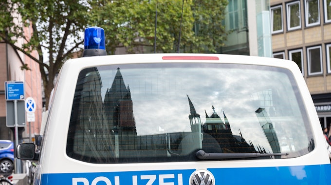 Köln: Der Dom spiegelt sich in einem Fenster eines Polizeifahrzeuges. (Symbolbild)