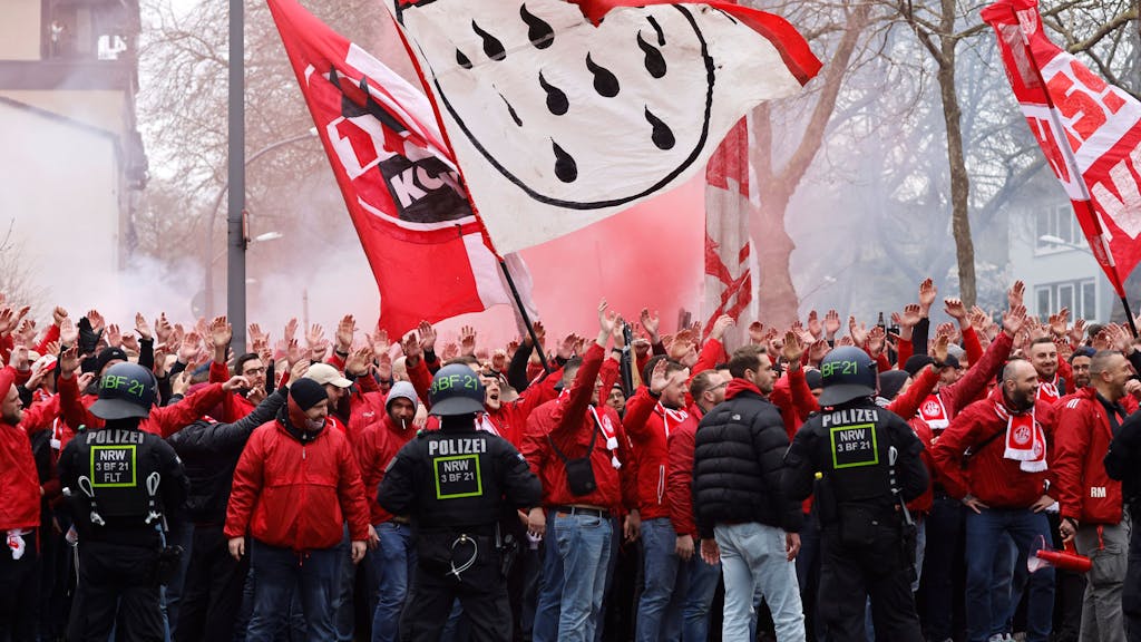 Mehrere Hundert Fans des 1. FC Köln ziehen vor dem Derby begleitet von Einsatzkräften der Polizei in einem Fanmarsch zum Stadion.