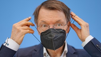 Bundesgesundheitsminister Karl Lauterbach (SPD) zieht eine FFP2-Maske am Ende einer Pressekonferenz zur Corona-Lage im Sommer 2022 in der Bundespressekonferenz auf. Die Maskenpflicht ist bald Geschichte.