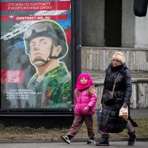 Menschen gehen an einem Rekrutierungsplakat der Armee mit der Aufschrift „Militärdienst unter Vertrag in den Streitkräften“ in Sakt Petersburg vorbei.