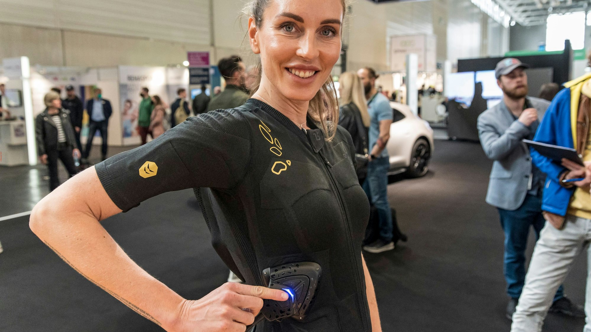 Ein Modell drückt sich ein elektronisches Fitness-Messgerät an die Hüfte: Nach zwei Jahren Corona-Pause hatte im April 2022 in der Kölnmesse wieder die Fitnessmesse Fibo stattgefunden.