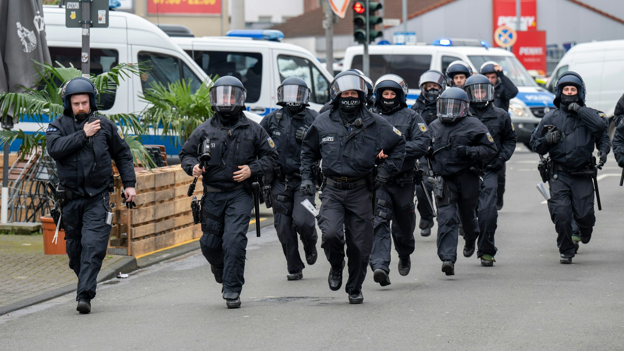 Ein Polizeitrupp bewegt sich im Laufschritt am Bahnhof Ehrenfeld. Dort kamen Fans von Borussia Mönchengladbach an.