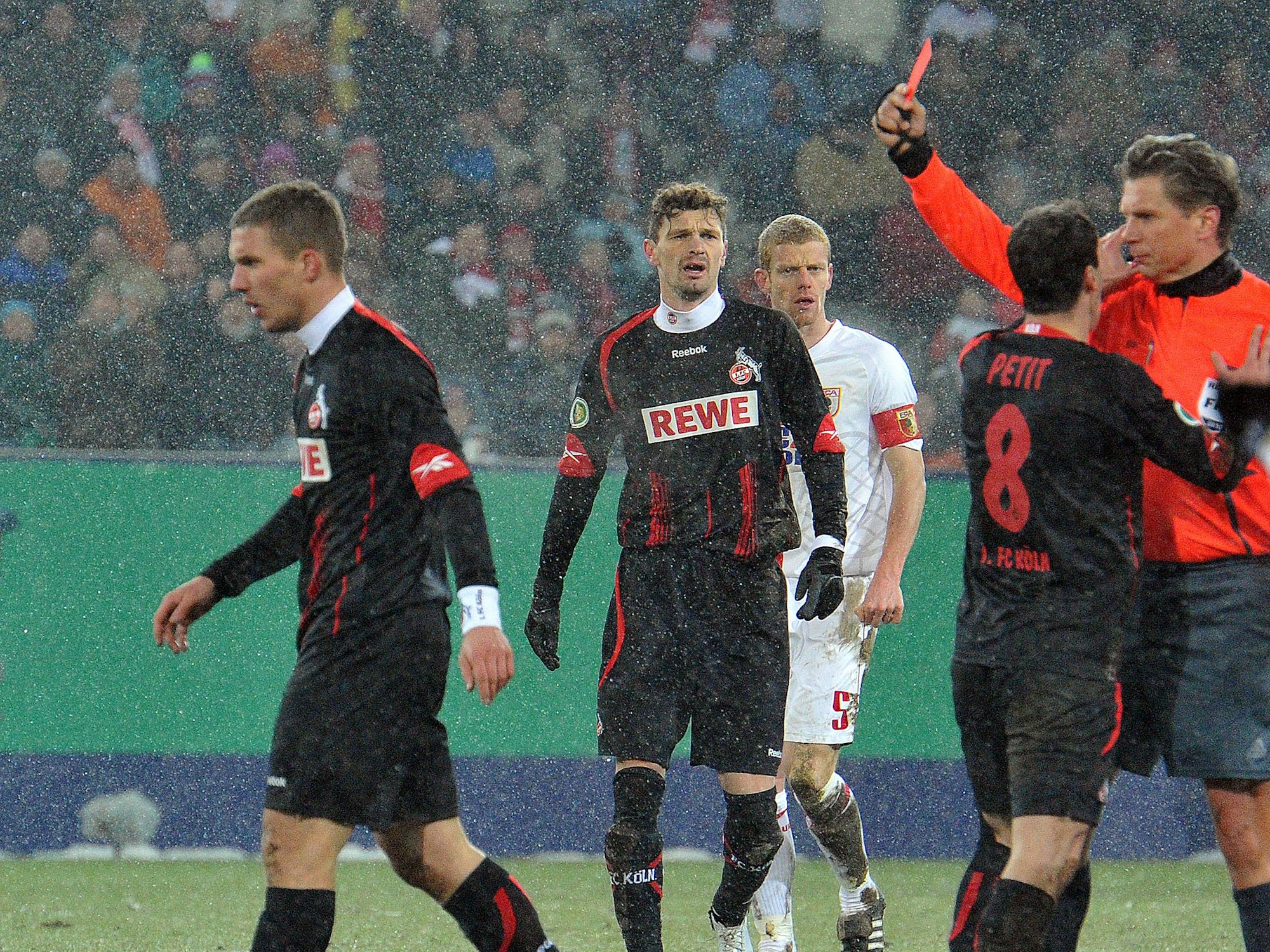 Der Kölner Lukas Podolski (l) bekommt von Schiedsrichter Torsten Kinhöfer (r) die Rote Karte.