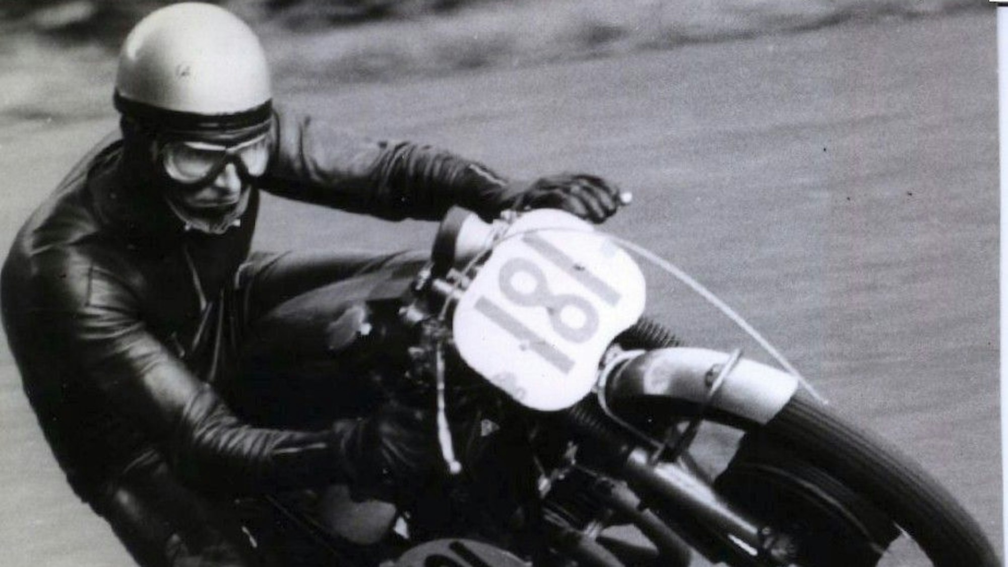 Der Rennfahrer legt sich mit seinem Motorrad in die Kurve.