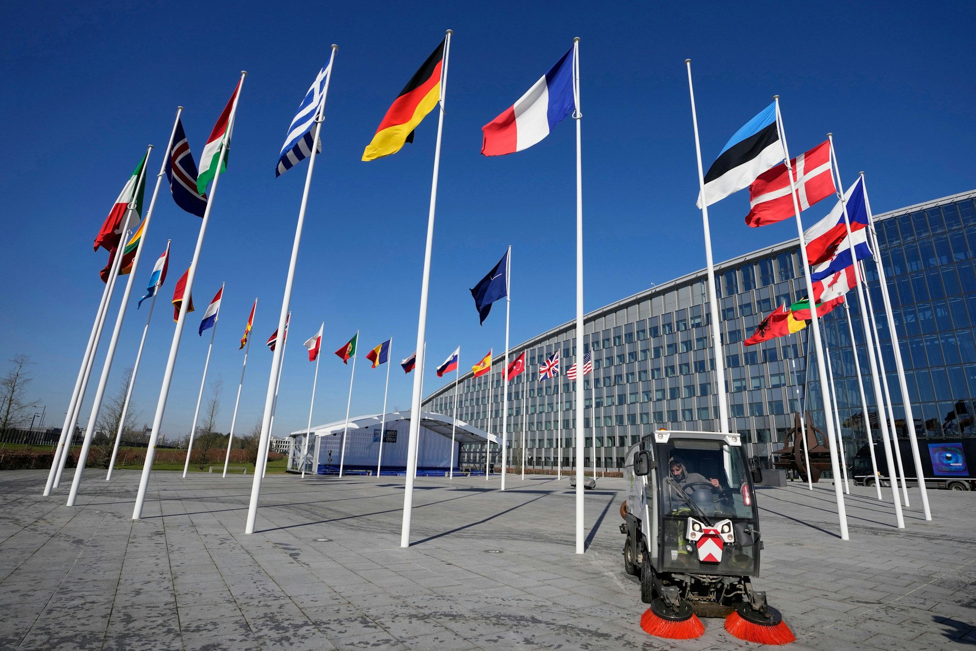 Ein leerer Fahnenmast steht zwischen den Nationalflaggen von Frankreich und Estland vor dem Nato-Hauptquartier.