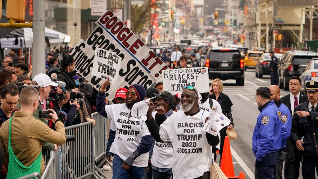 Anhänger des ehemaligen Präsidenten Donald Trump tragen ihre Schilder vor versammelten Medienvertretern und Schaulustigen vor dem Strafgericht in Manhattan, Dienstag, 4. April 2023, in New York.&nbsp;