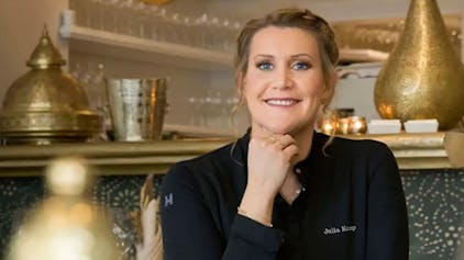 Julia Komp sitzt lächelnd in ihrem Restaurant „Sahila“.