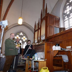 Zu sehen sind drei Männer vor einer Orgel in der Kirche St. Mariä Heimsuchung in Morsbach-Holpe.
