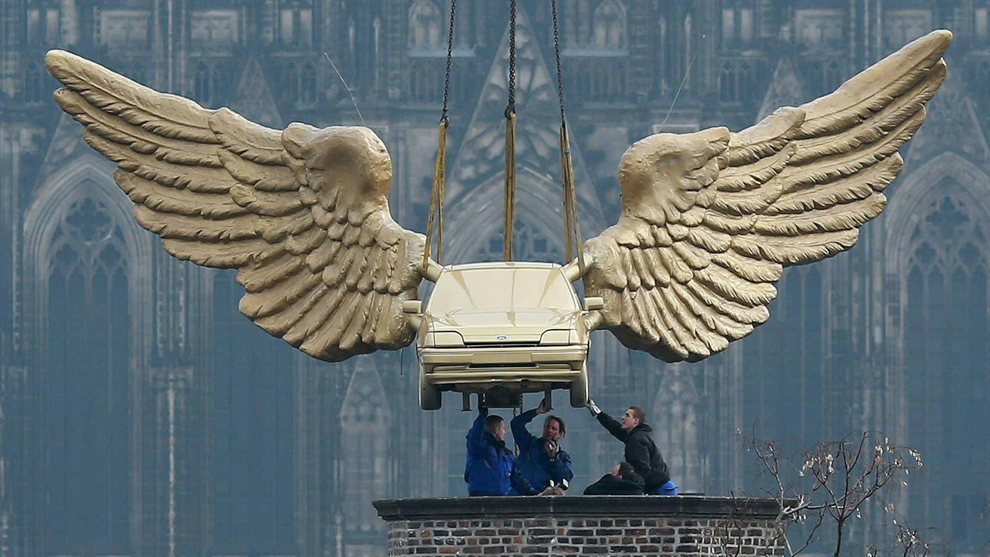 2013: Das Flügelauto des Aktionskünstlers HA Schult hängt an einem Kran und wird auf den Turm des Kölnischen Stadtmuseums in Köln gesetzt. Nach einer fünfmonatigen Restaurierungsphase kehrt der Ford Fiesta an seinen angestammten Platz in Sichtweite des Kölner Doms zurück.