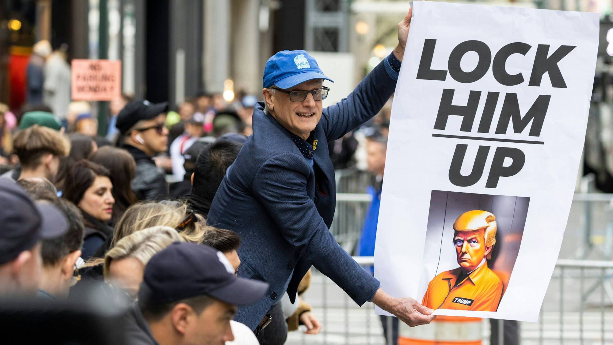 Ein Mann hält in New York ein Plakat, das die Verhaftung des Ex-Präsidenten fordert.
