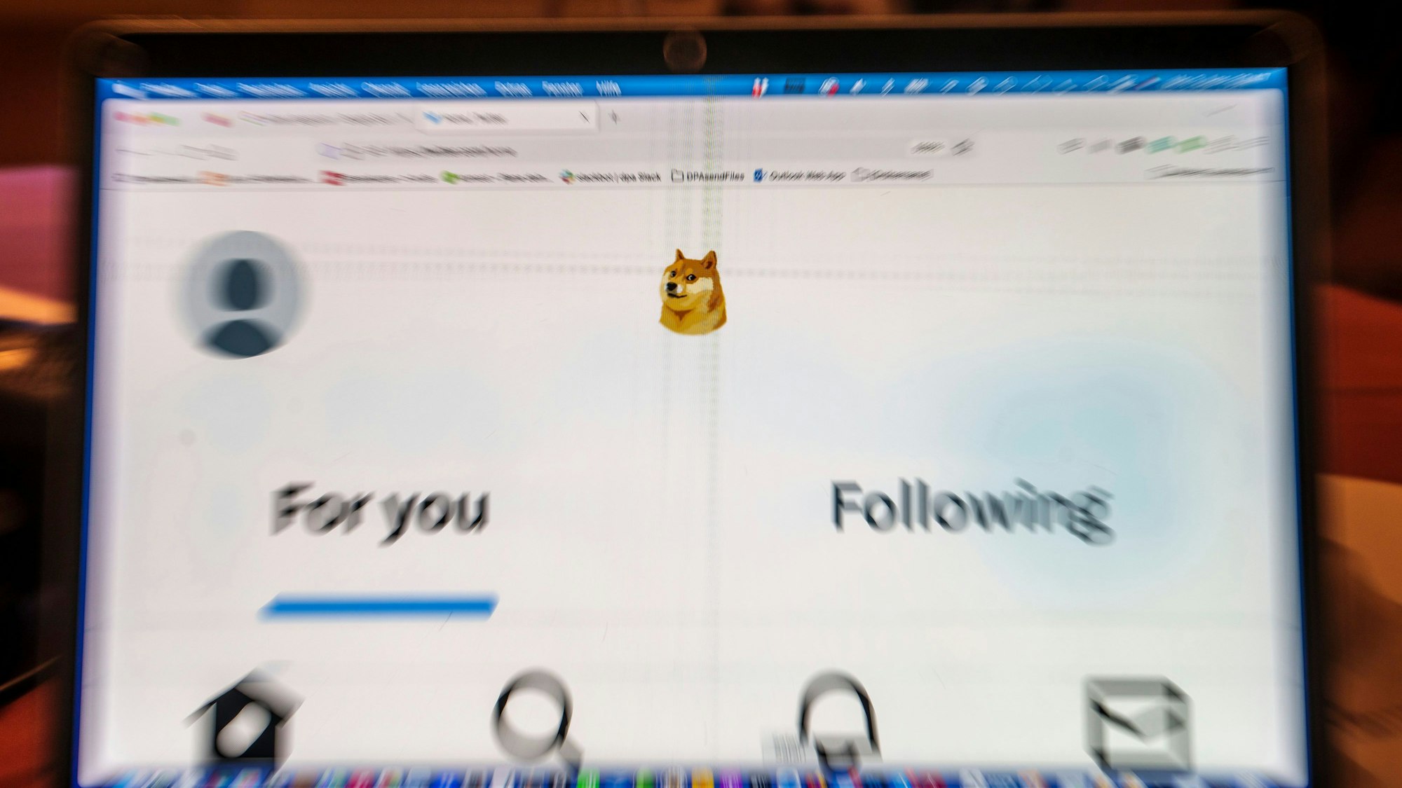 Auf einem Laptop-Display ist die Startseite von Twitter zu sehen, die anstelle des Twitter-Logos das Symbol der Digitalwährung Dogecoin zeigt.