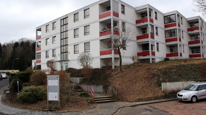 Das Seniorenzentrum Otterbach in Bad Münstereifel steht leicht erhöht. Auf einem Parkplatz rechts unten vor dem Gebäude parkt ein graues Auto. Links unten im Bild führt eine Straße entlang.