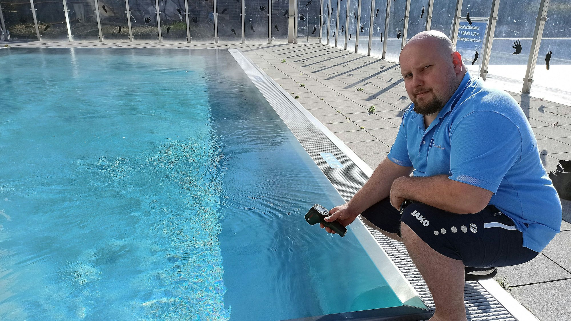 Denis Klein, Fachangestellter für Bäderbetriebe, misst die Wassertemperatur im Bornheimer Hallenfreizeitbad. Foto: Frank Engel-Strebel