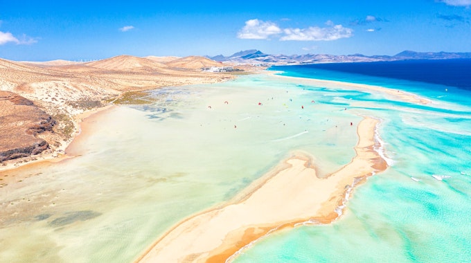 Hier zu sehen, ein Sandstrand am Meer auf der Ferieninsel Fuerteventura.