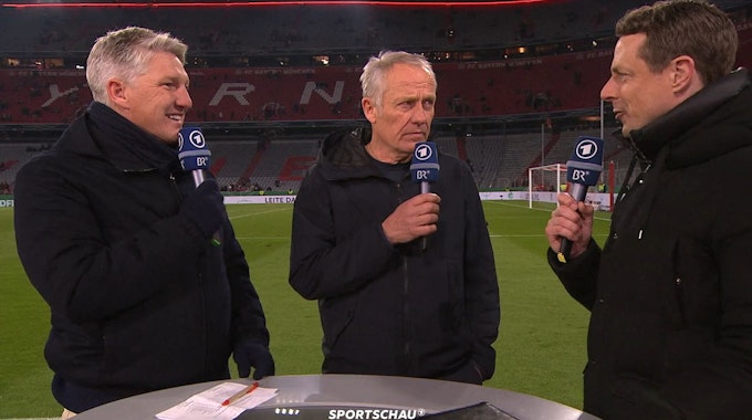 Christian Streich (M.) zwischen Bastian Schweinsteiger (l.) und Alexander Bommes im ARD-Interview nach Freiburgs Sieg im DFB-Pokal beim FC Bayern.