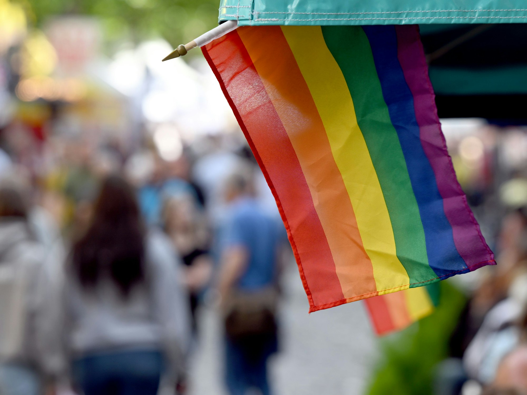 Regenbogenflaggen sind an einem Marktstand angebracht.