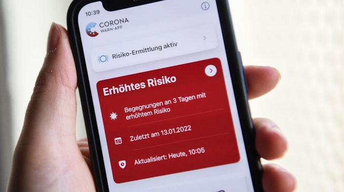 Auf einem Smartphone zeigt die geöffnete Corona-Warn-App ein erhöhtes Risiko an. Die rote Anzeige warnt vor drei Begegnungen mit Corona-positiv getesteten Personen. Foto vom 19. Januar 2022.