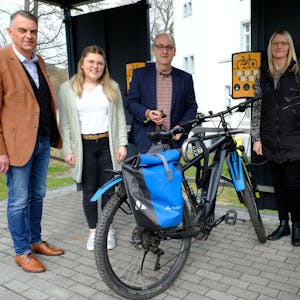 Zwei Männer und zwei Frauen stehen mit Fahrrädern an der E-Bike-Ladestation in Hellenthal.