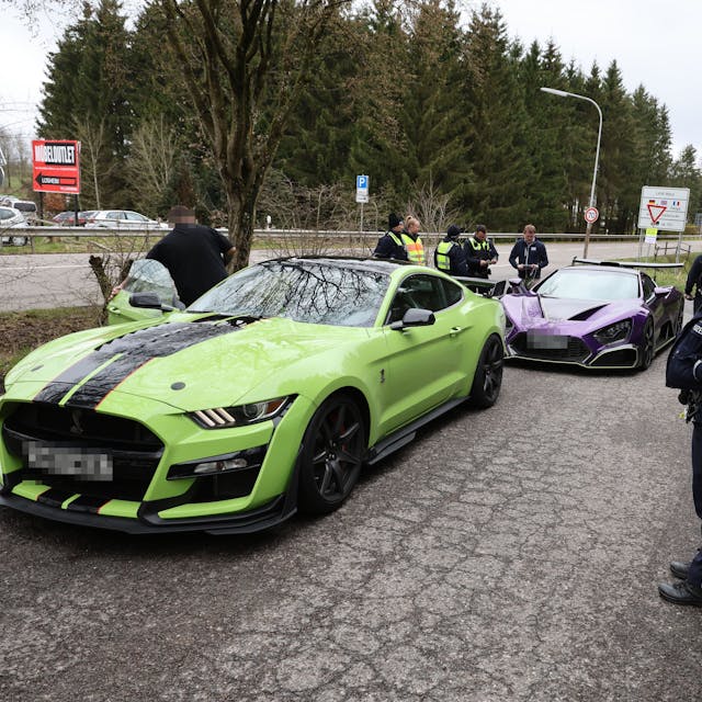 Zwei Sportwagen aus den Niederlanden sind von Polizisten herausgewunken worden und werden auf einem Parkplatz in Losheim kontrolliert.