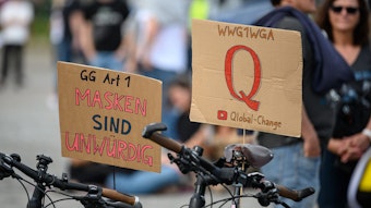 Schilder auf einer Protestkundgebung der Initiative „Querdenken 711“ in Stuttgart. Das „Q“ steht für die Verschwörungstheorie „QAnon“, die aus den USA stammt. „WWG1WGA“ ist ein Slogan von QAnon und steht für „Where We Go One We Go All.“ (deutsche ungefähre Übersetzung: „Wohin wir gehen, gehen wir alle“).