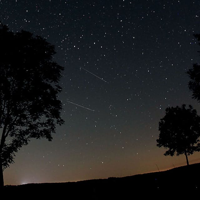 Sternschnuppen der Perseiden (Bildmitte) sind in der Nähe von Nettersheim in der Eifel am Nachthimmel zu sehen.