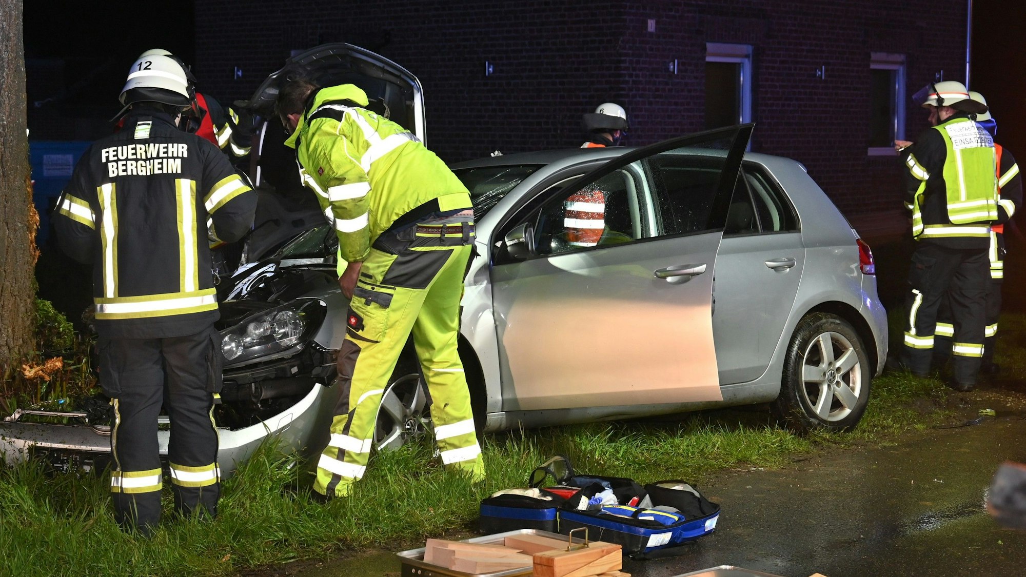 Das Bild zeigt Einsatzkräfte der Feuerwehr Bergheim an dem silbernen VW-Golf. Das Fahrzeug war gegen einen Baum geprallt.