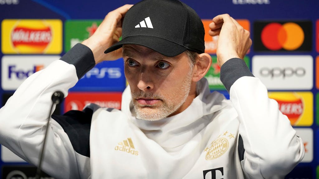 Thomas Tuchel richtet sich auf einer Pressekonferenz des FC Bayern seine Kappe.
