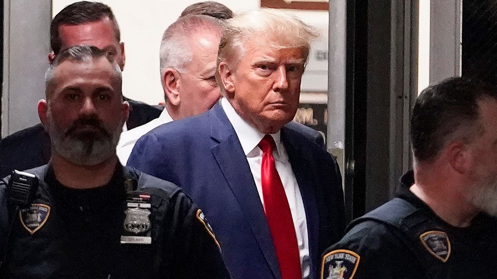 Donald Trump wird von Polizeibeamten in den Gerichtssaal begleitet.