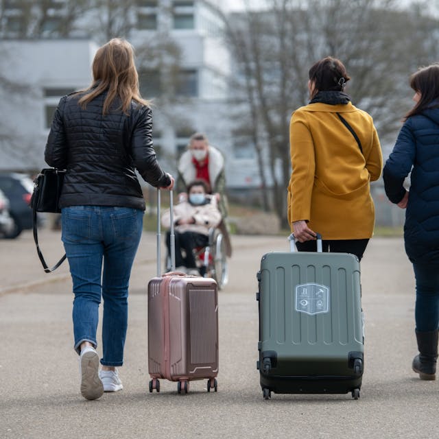 Drei aus der Ukraine stammende Frauen gehen in der Landeserstaufnahmestelle für Flüchtlinge (LEA) zu ihrem Quartier.