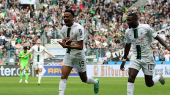 Nathan Ngoumou (l.) bejubelt seinen ersten Bundesliga-Treffer mit Marcus Thuram im Spiel von Borussia Mönchengladbach gegen den VfL Wolfsburg am 9. April 2023.