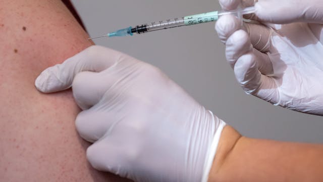 ARCHIV - 19.11.2021, Bayern, Haar: Ein Mann bekommt im Impfzentrum eine Booster-Impfung gegen Covid-19.&nbsp;