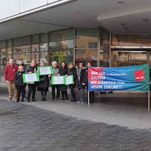Beschäftigte der Siegburger Filiale von Galeria Karstadt Kaufhof stehen mit Schildern und Bannern vor der Filiale.&nbsp;