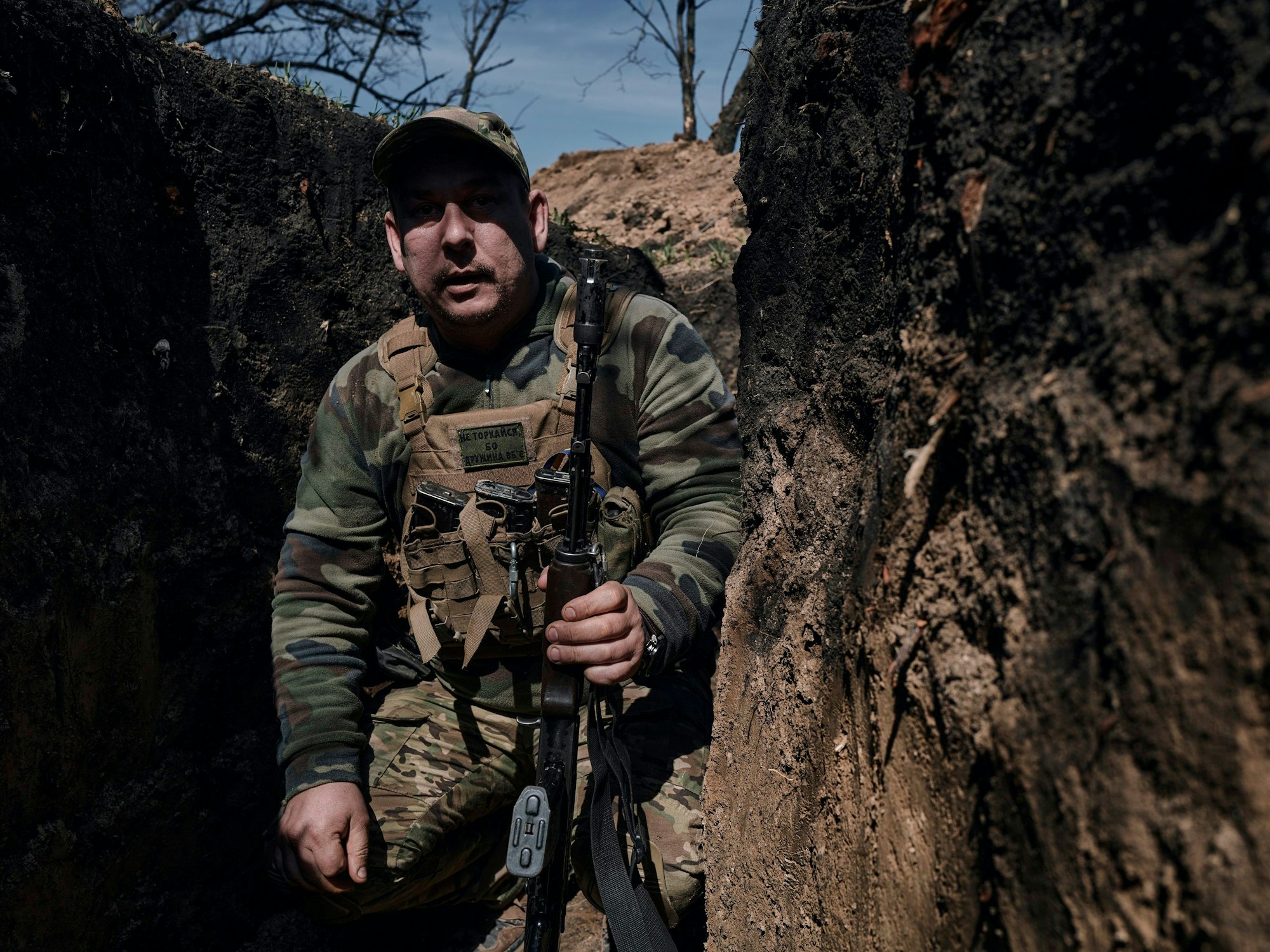 Ein ukrainischer Soldat geht in einem Graben an der Frontlinie in Bachmut.