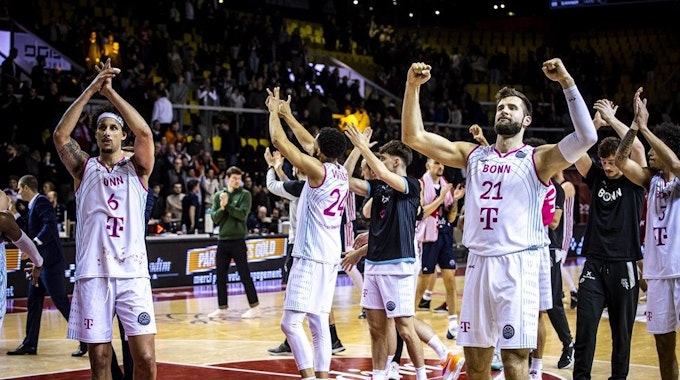 Spieler der Telekom Baskets jubeln den Fans nach ihrem Sieg zu.