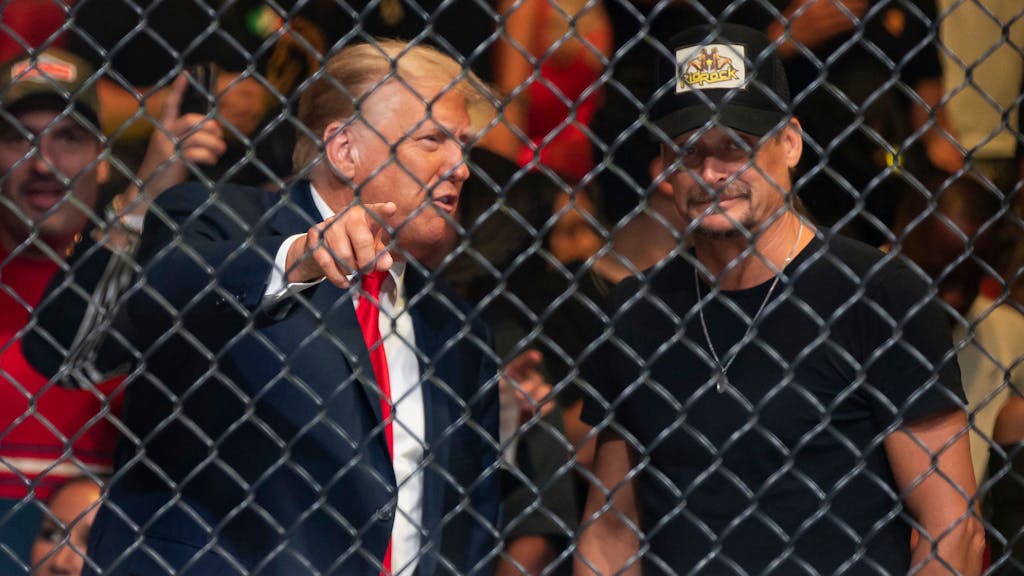 Donald Trump (l), ehemaliger Präsident der USA, und Kid Rock (r), Musiker aus den USA, unterhalten sich während des Kampfsportevents in Miami.