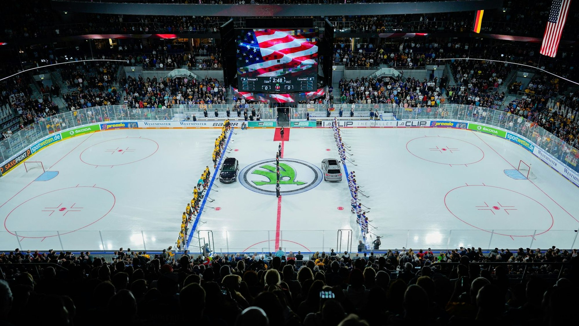 Die Spieler beider Mannschaften stehen vor Spielbeginn im Jahr 2019 bei der Darbietung der Nationalhymnen auf dem Eis.