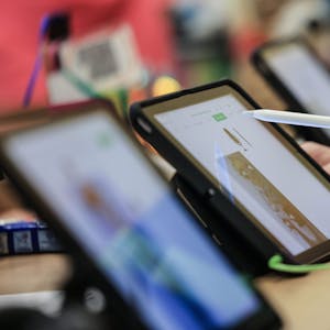 Schüler lernen in einer Klasse in der Grundschule am iPad.