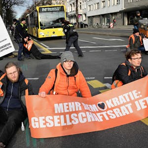 Klimaaktivisten festgeklebt auf der Straße am Demonstrieren