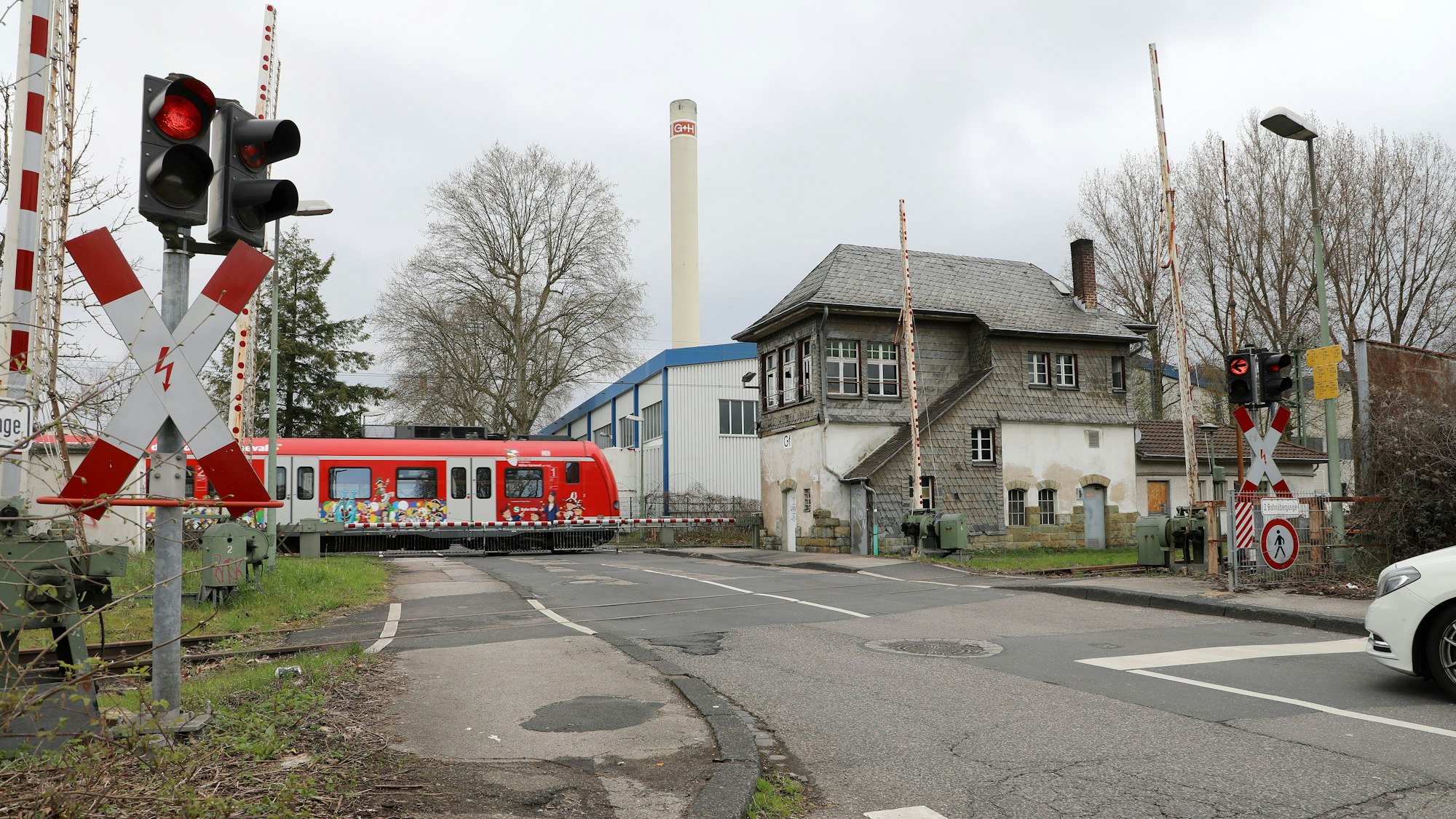 Eine Bahn fährt über den Bahnübergang an der Tannenbergstraße in Bergisch Gladbach.
