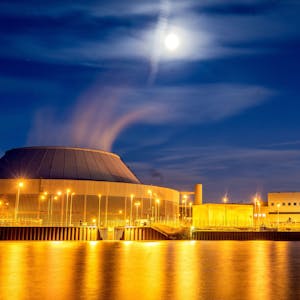 Der Mond leuchtet zur blauen Stunde über dem Kernkraftwerk Neckarwestheim.