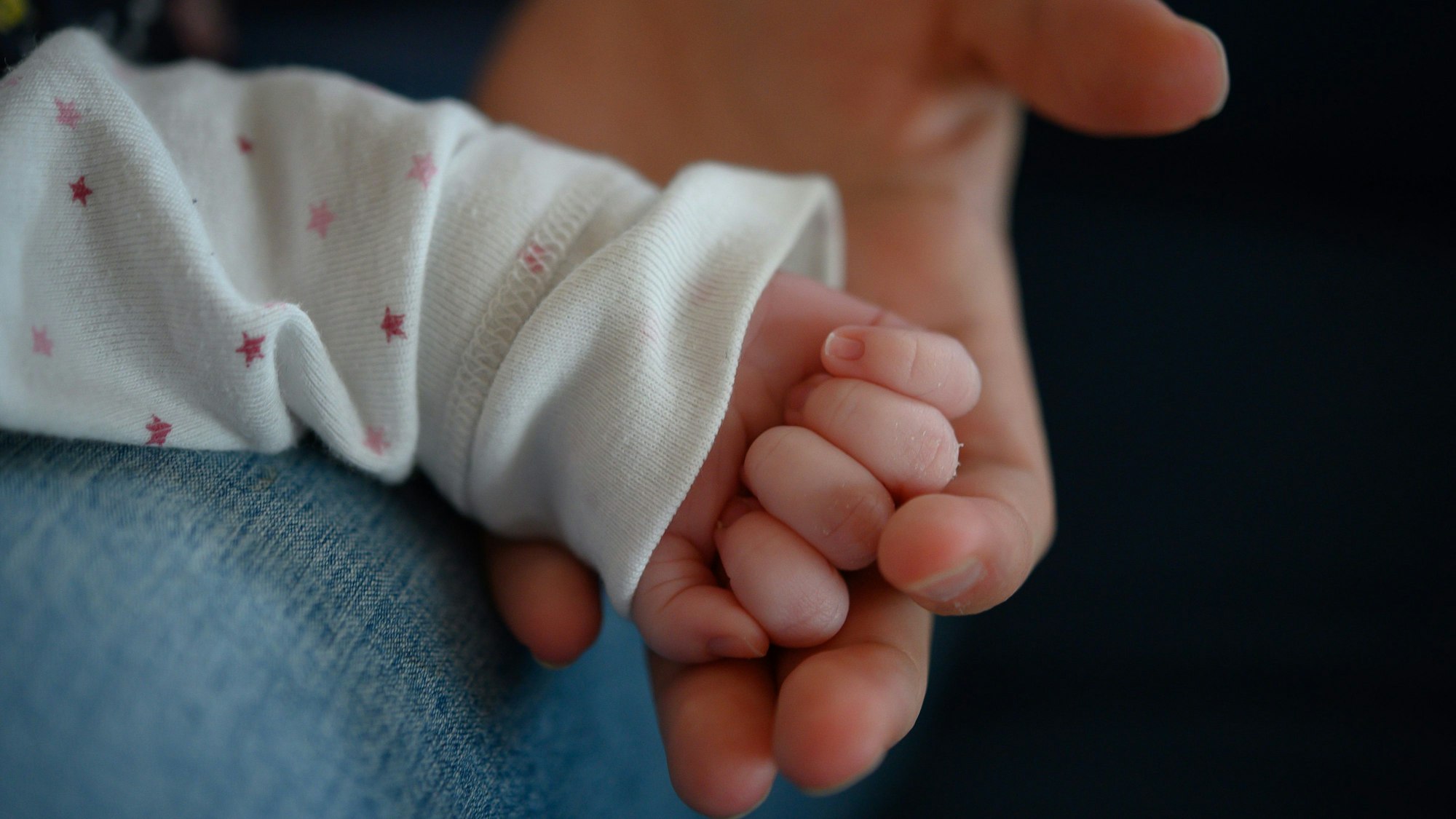 Die Hand eines zwei Wochen altes Neugeborenen liegt in der Hand seiner Mutter. (Symbolbild)