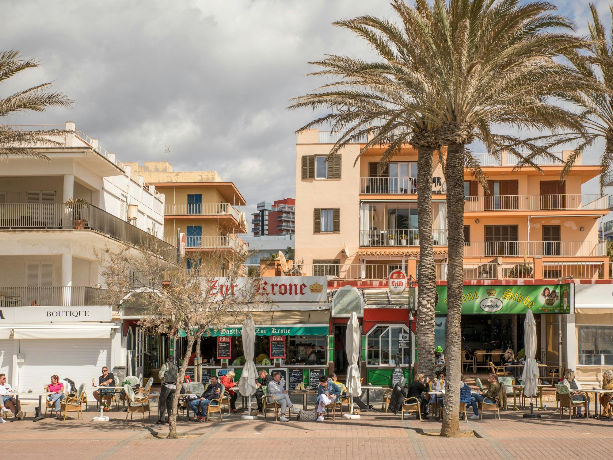 Deutsche Touristen und Touristinnen, hier im März 2021, sitzen in der Bar „Zur Krone“ und „Krone Stube“ und genießen einen Drink in der Sonne an der Playa de Palma auf Mallorca.