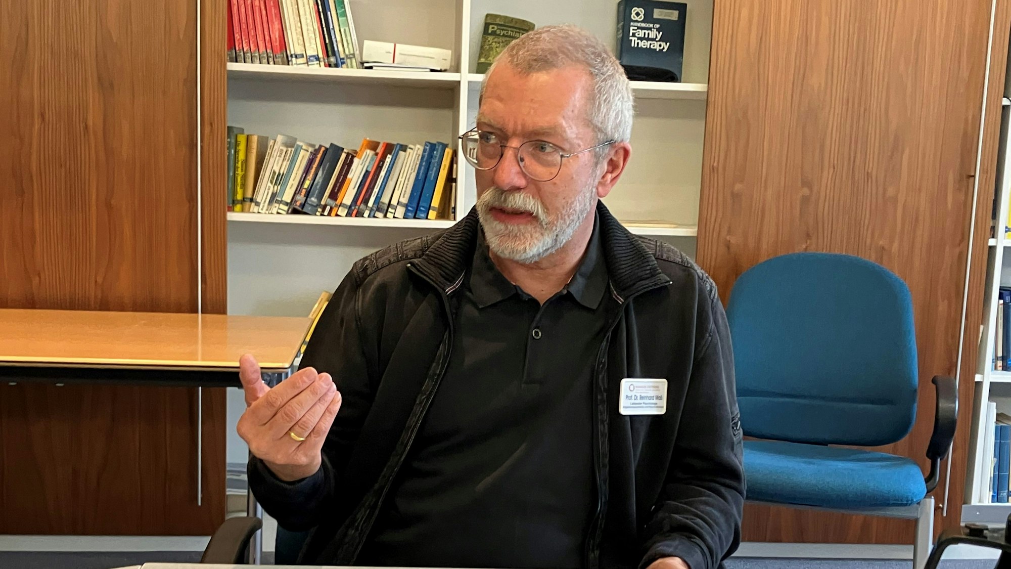 Prof. Dr. Reinhard Maß sitzt an einem Tisch und gestikuliert mit einer Hand.
