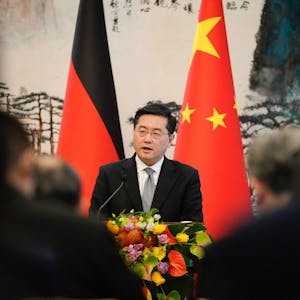 Außenminister Qin Gang spricht vor einer chinesischen sowie einer deutschen Flagge.